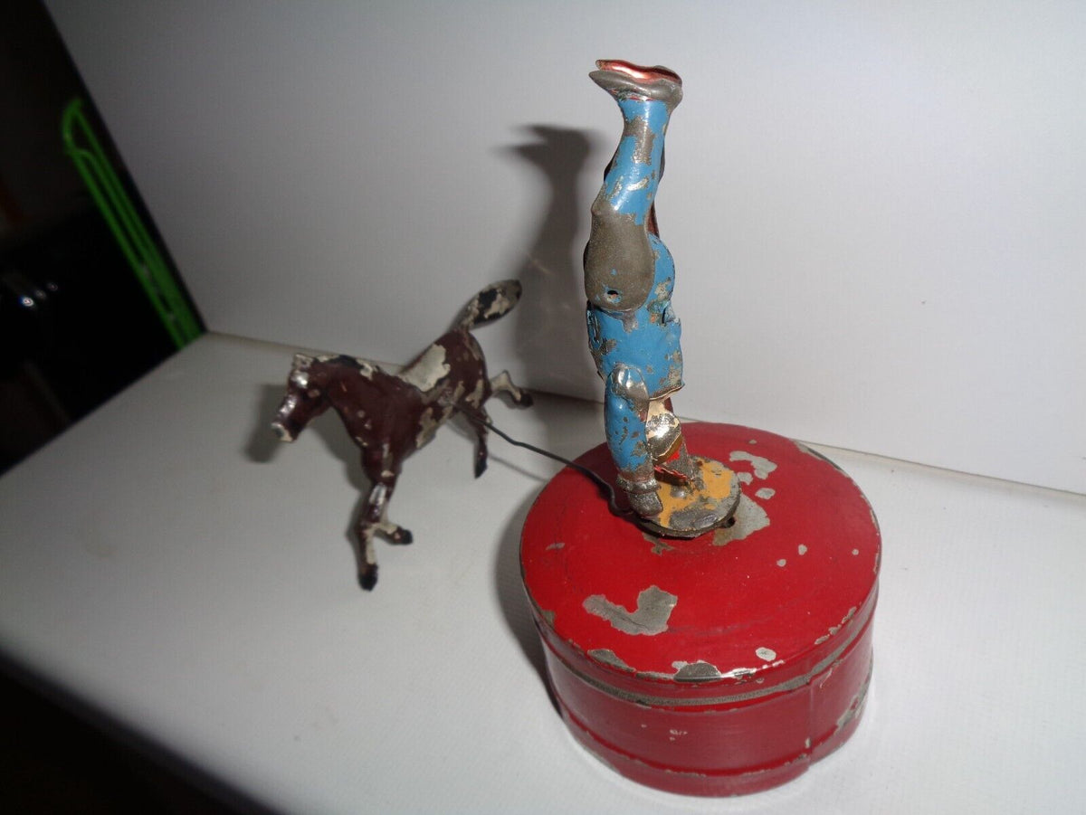 Mechanical circus toy depicting a clown balancing on its hands