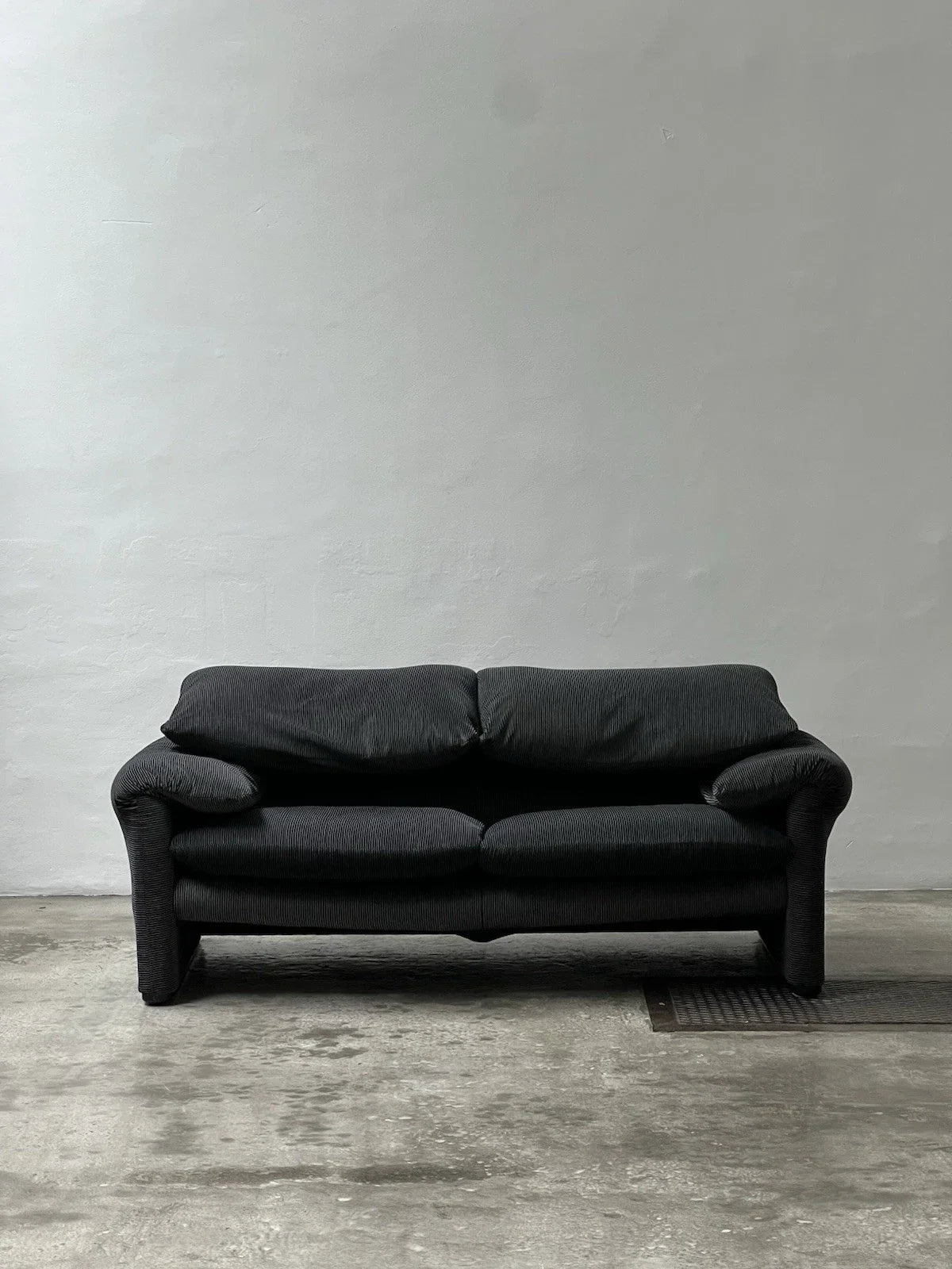 2-seater sofa with a sleek design by Enzo Magistretti for Cassina.