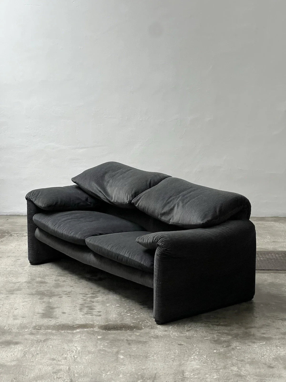 2-seater sofa with a sleek design by Enzo Magistretti for Cassina.