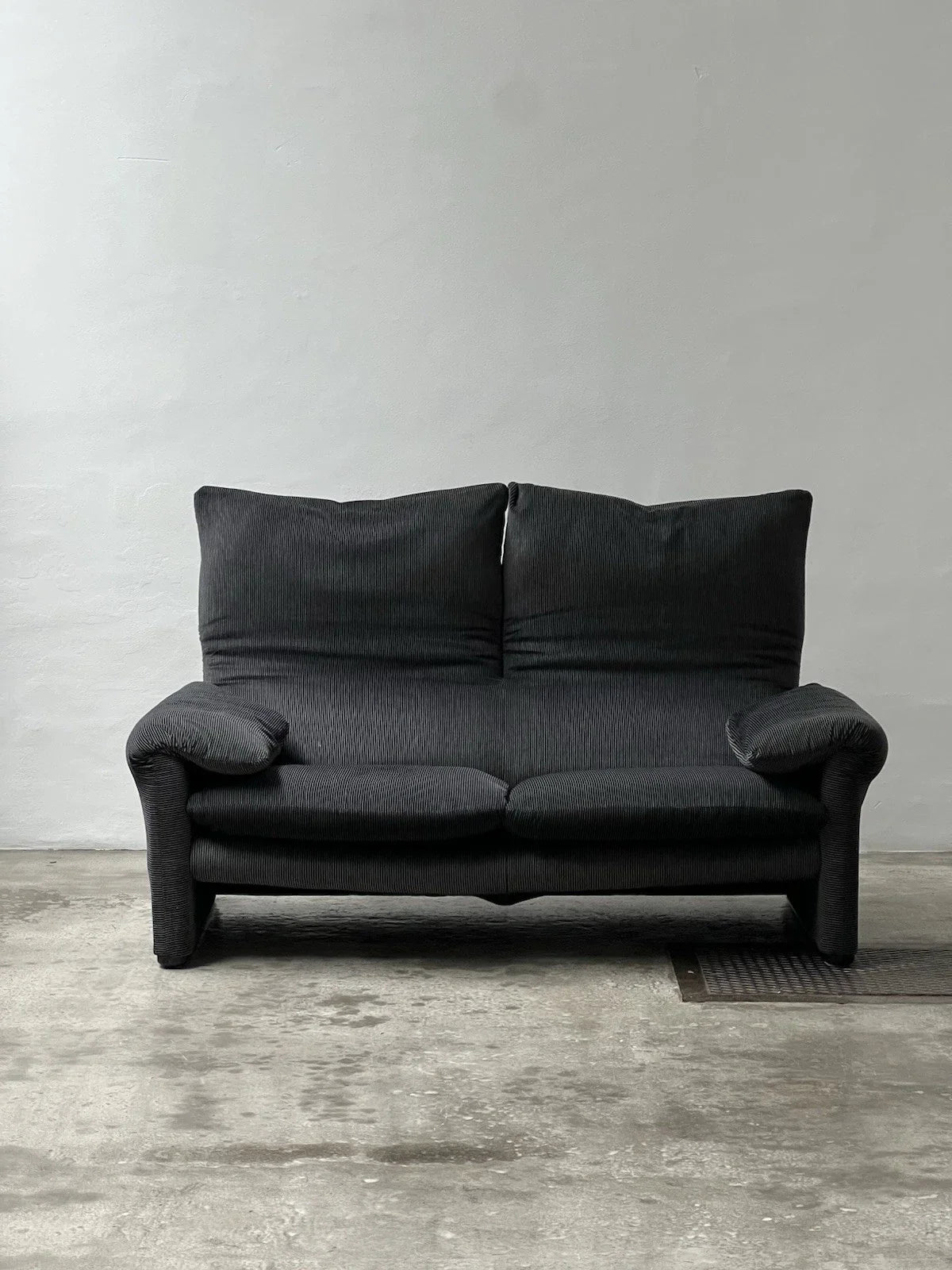 2-seater sofa with a sleek design by Enzo Magistretti for Cassina.