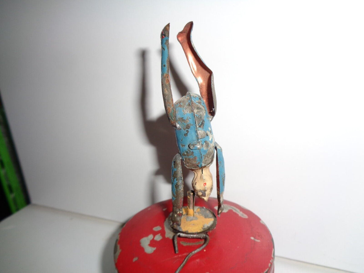 Mechanical circus toy depicting a clown balancing on its hands