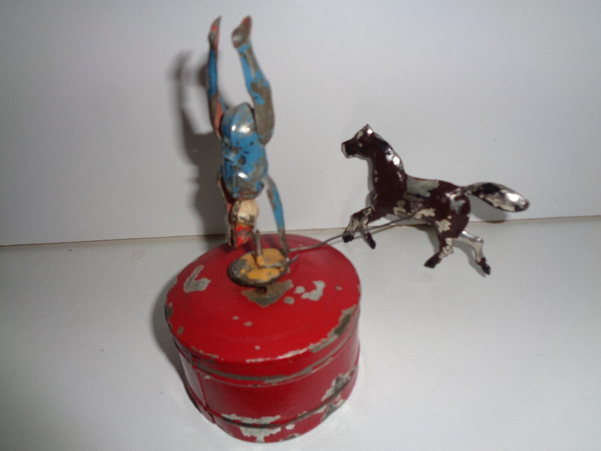 Mechanical circus toy depicting a clown balancing on its hands
