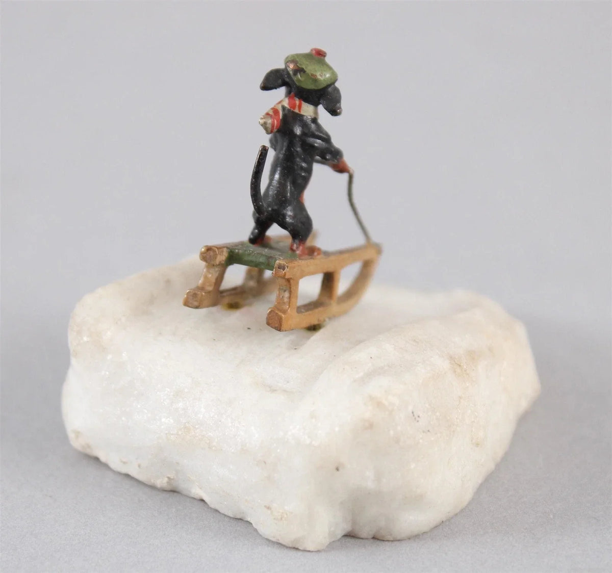 Antique Austrian miniature bronze sculpture depicting a dachshund sledding in the snow.