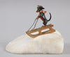 Antique Austrian miniature bronze sculpture depicting a dachshund sledding in the snow.