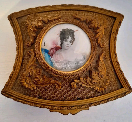 Antique tufted jewelry box with bronze or brass medallion